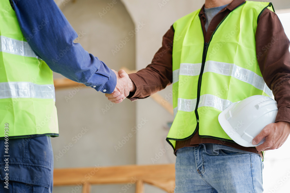 Two engineer businessman handshake after deal planning about building together in construction site - obrazy, fototapety, plakaty 
