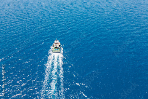 Aerial view of Fishing ship in cruising open Aegean sea