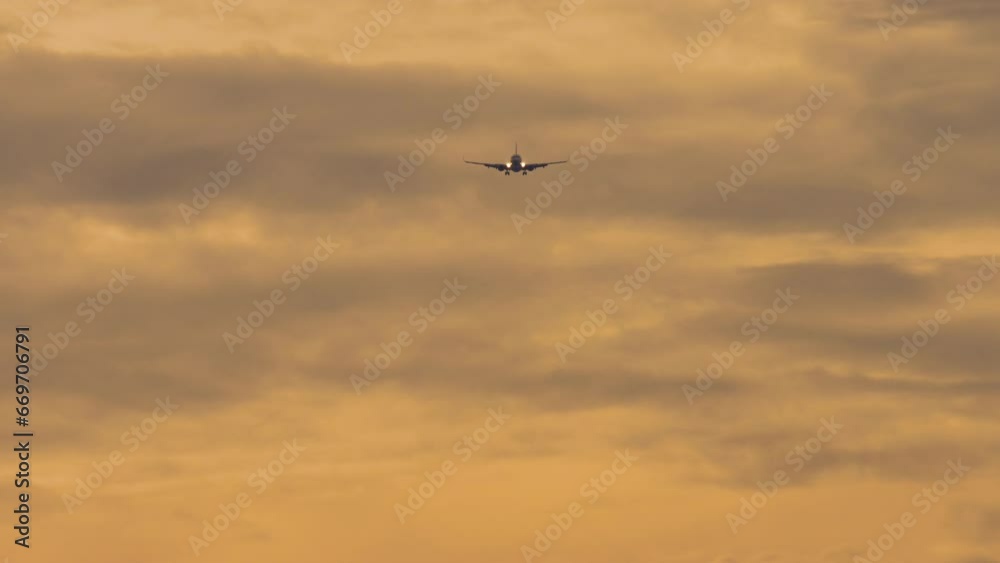 Jet plane approaching landing. Passenger airliner flies in the sunset sky, front view, long shot Jet plane approaching landing. Passenger airliner flies in the sunset sky, front view, long shot