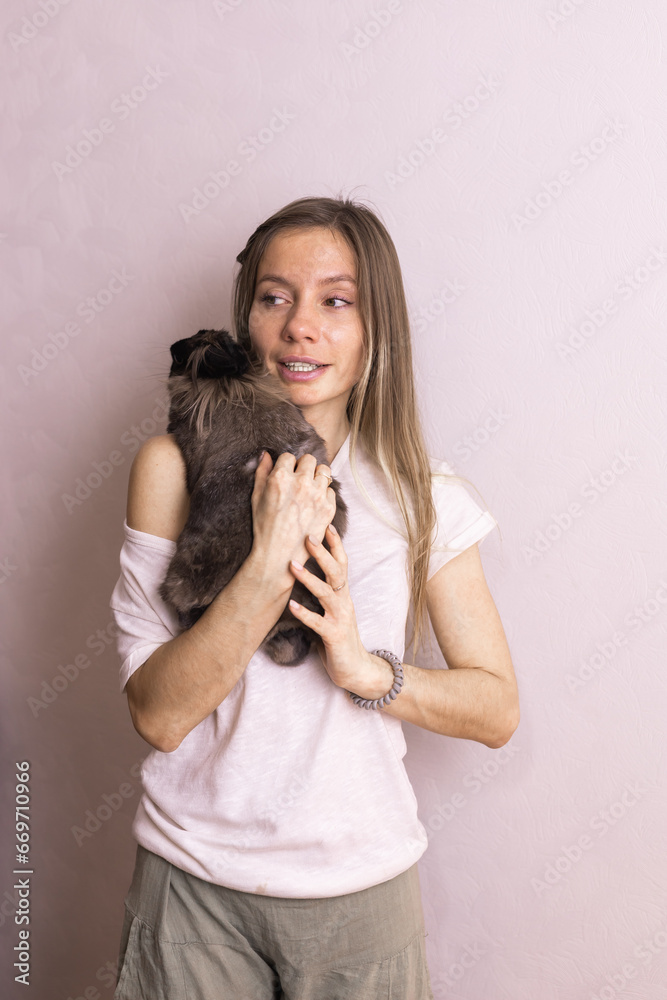Young woman with adorable rabbit indoors, close up. Lovely pet and animal concept