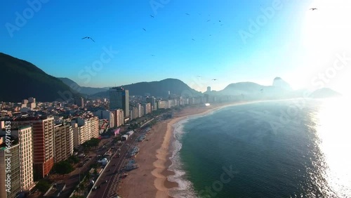 Aerial Ascending Shot Of Birds Flying Over Beach Near Buildings In City Against Sky - Rio de Janeiro, Brazil