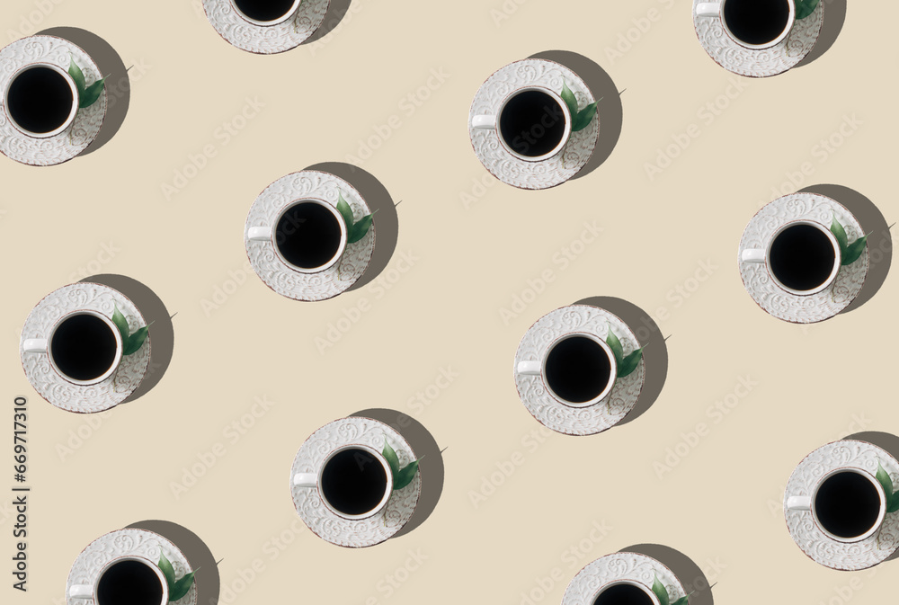 Trendy pattern composition made of white cup of coffee decorated with green leaves on light cream background. Creative coffee concept. Minimal pattern idea. Coffee aesthetic background. Flat lay. Trendy pattern composition made of white cup of coffee decorated with green leaves on light cream background. Creative coffee concept. Minimal pattern idea. Coffee aesthetic background. Flat lay.