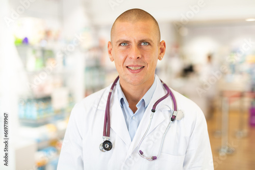 Portrait of positive friendly pharmacist or doctor in pharmacy closeup