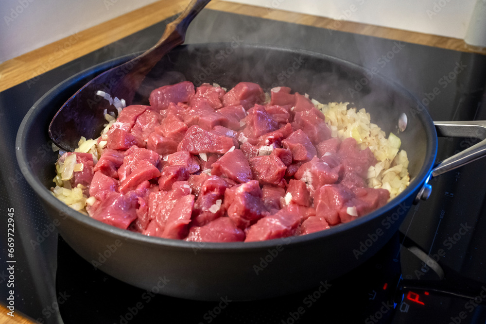 raw meat and chopped onion on cooking pan raw meat and chopped onion on cooking pan