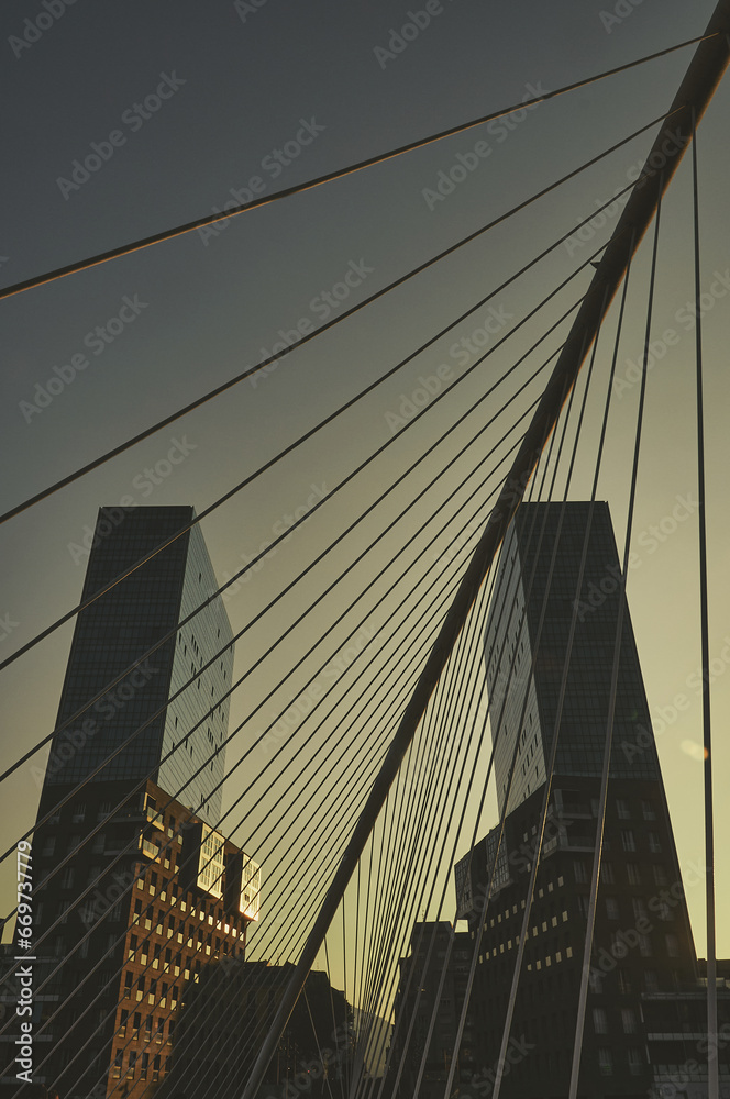 Obraz premium Glass Towers Beyond the Bridge: Urban Skyline View from the Bridge