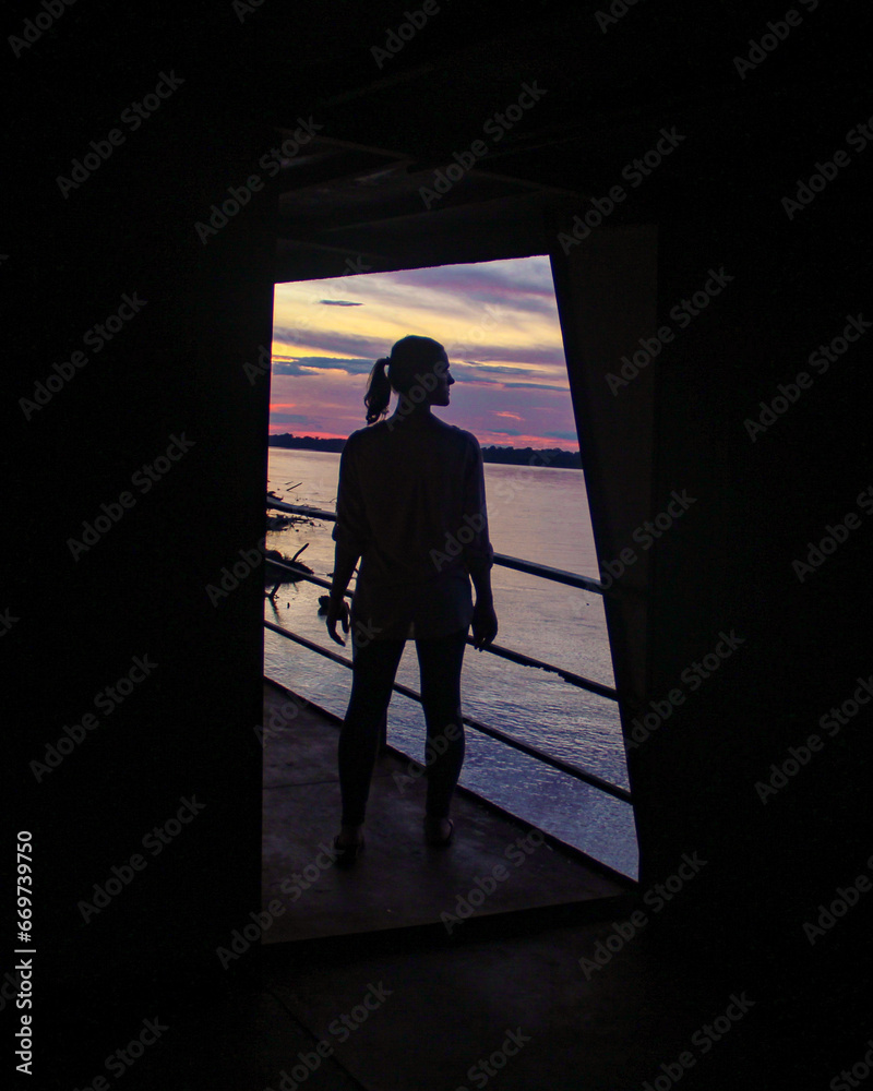 silhueta de mulher com por do sol no rio amazonas, no peru, ao fundo silhueta de mulher com por do sol no rio amazonas, no peru, ao fundo