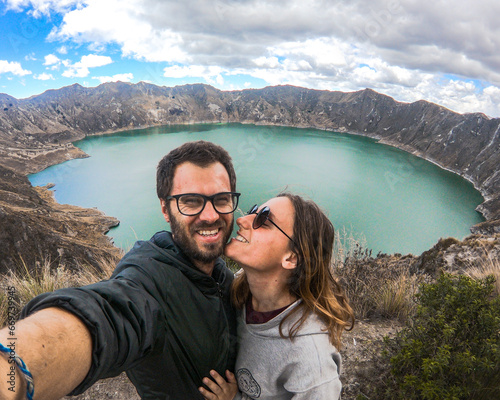 selfie de casal em frente a laguna quilotoa, no equador photo