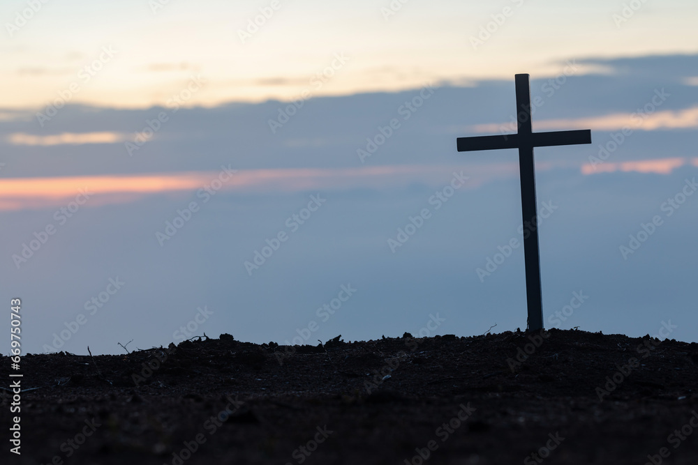 Silhouettes of crucifix symbol on top mountain with bright sunbeam on the colorful sky background
