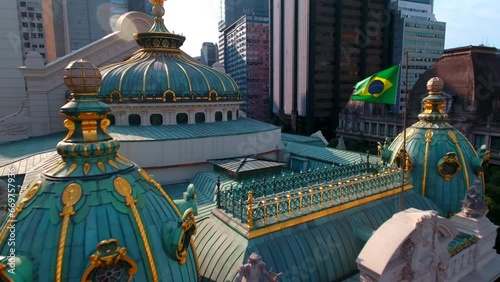 Aerial Backward Shot Of Theatro Municipal With A Flag Amidst Buildings In City - Rio de Janeiro, Brazil photo