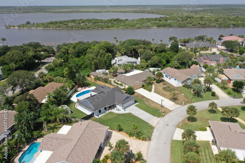 Aerial of Daytona Beach area Halifax River front residential neighborhood, featuring a homes with in-ground swimming pools.