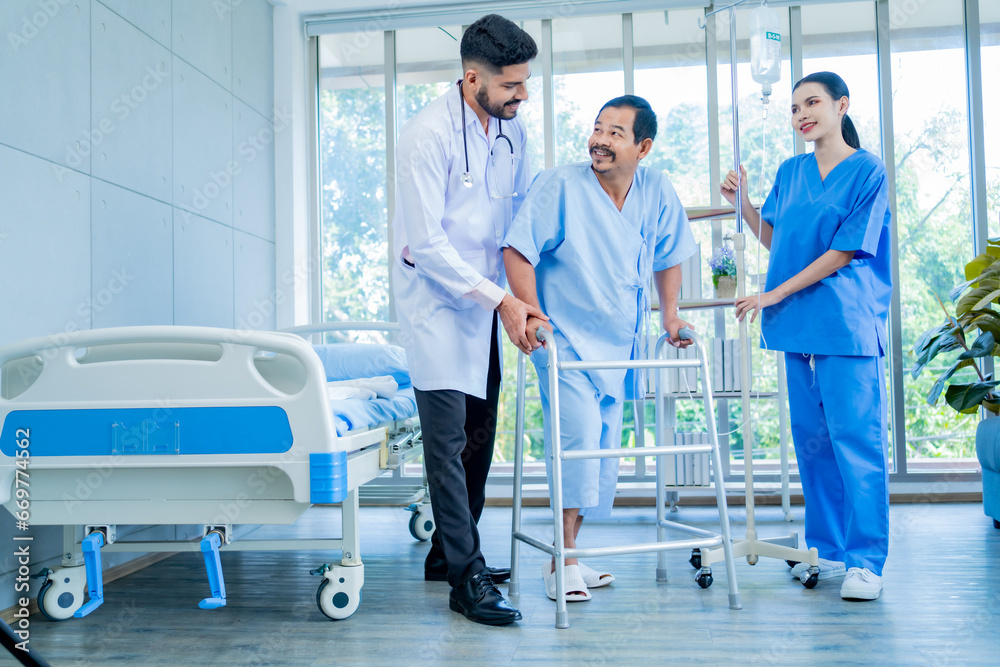 Obraz premium A Muslim male doctor and nurse help a patient who is doing physical therapy and is practicing walking with a walking stick.