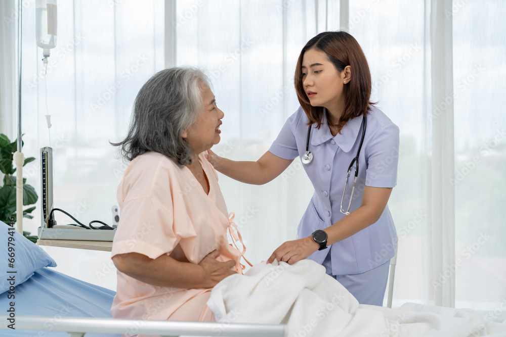 Obraz premium A nurse or caregiver for an elderly patient is helping a patient with severe stomach problems