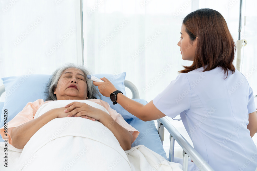 Obraz premium Nurse uses a digital thermometer to take her temperature.