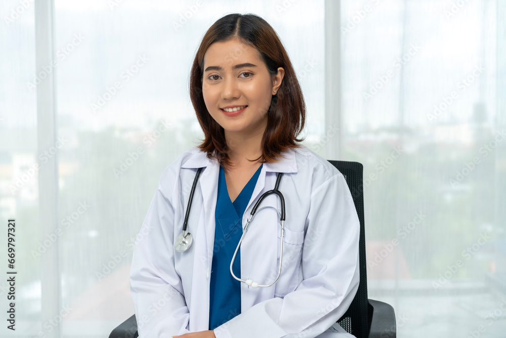 Portait of young asian female doctor in white coat looking at camera in hospital. Portait of young asian female doctor in white coat looking at camera in hospital.