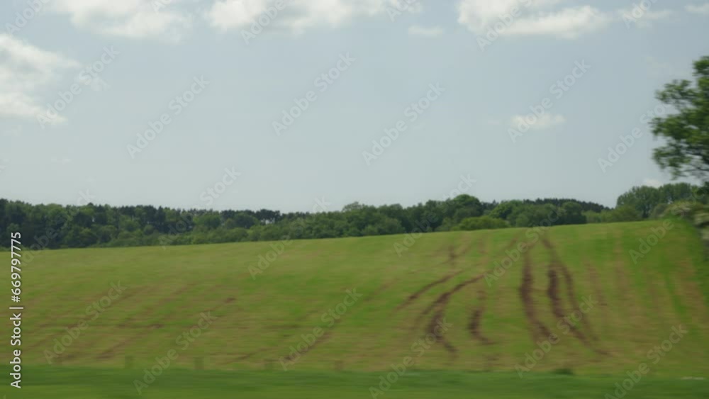 Trees and fields of the countryside as seen from the window of a moving train on a spring afternoon in the UK Trees and fields of the countryside as seen from the window of a moving train on a spring afternoon in the UK
