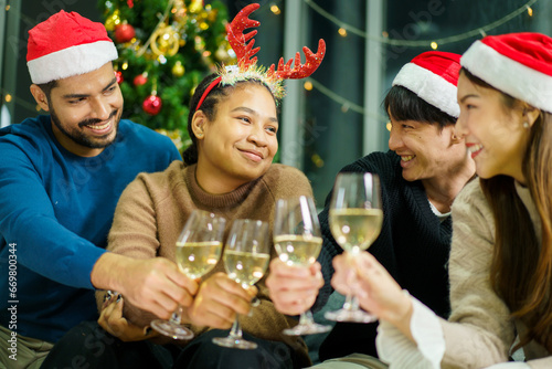 Group of diverse ethnicity young people enjoy celebrating a Christmas and New Year party together with a lot of foods and drinks. Friends celebrate Christmas and New Year festival and drink a wine.