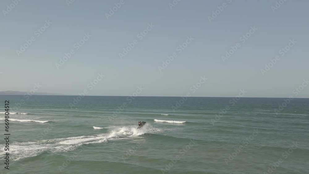 Jet ski riders jump over ocean surf waves at Noosa Heads river bar Jet ski riders jump over ocean surf waves at Noosa Heads river bar