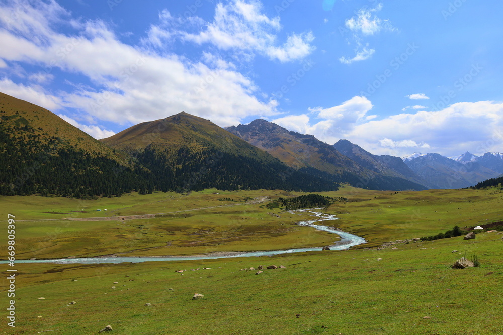 Turgenaksu valley with a river wading on a second stage of Ak-Suu Traverse trek in Karakol, Kyrgyzstan Turgenaksu valley with a river wading on a second stage of Ak-Suu Traverse trek in Karakol, Kyrgyzstan