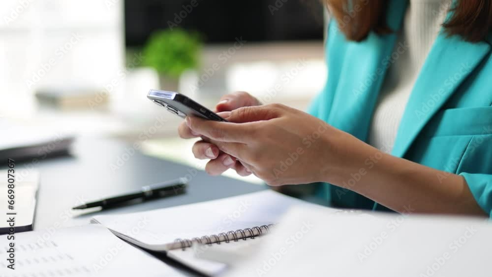 Businesswoman working in the home office is using mobile phone to send messages and chat with colleagues. Businesswoman working in the home office is using mobile phone to send messages and chat with colleagues.
