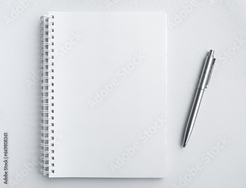 Mockup blank space on spiral notebook. White template on sketch book, vertical full page with silver pen. Top view of paper for draw, note, to do list for creative design and idea memo concepts.