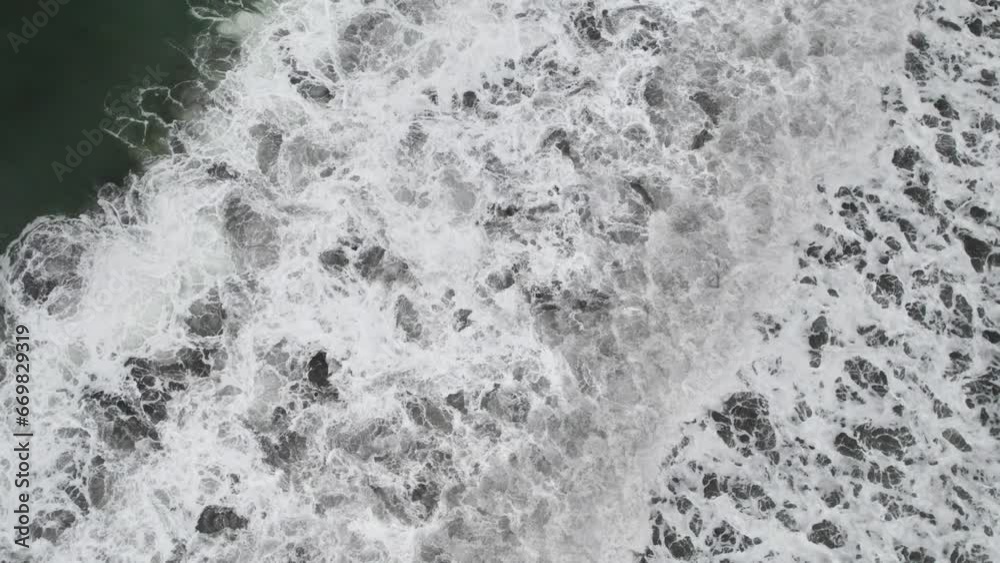 Waves crashing onto shore causing white foam, Playa Hermosa, Puntarenas
