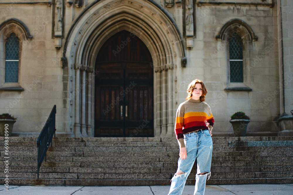 Pretty teen girl standing in front of cathedral church steps.