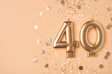 40 years celebration. Greeting banner. Gold candles in the form of number forty on peach background with confetti.
