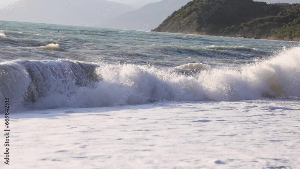 Slow Motion shot of foamy waves crushing on the beach on a summer day Slow Motion shot of foamy waves crushing on the beach on a summer day