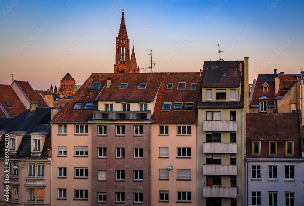 Grande Ile city skyline at sunset, tiled roofs and spires of Notre Dame Cathedral and Eglise du Temple Neuf church, Strasbourg, Alsace, France