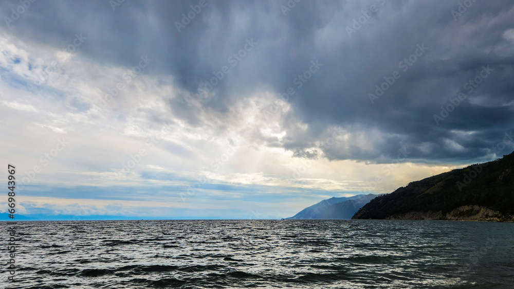 An impending thunderstorm. Clouds over the lake. clouds over the sea. The sun's rays break through the clouds over the lake. Selective focus.