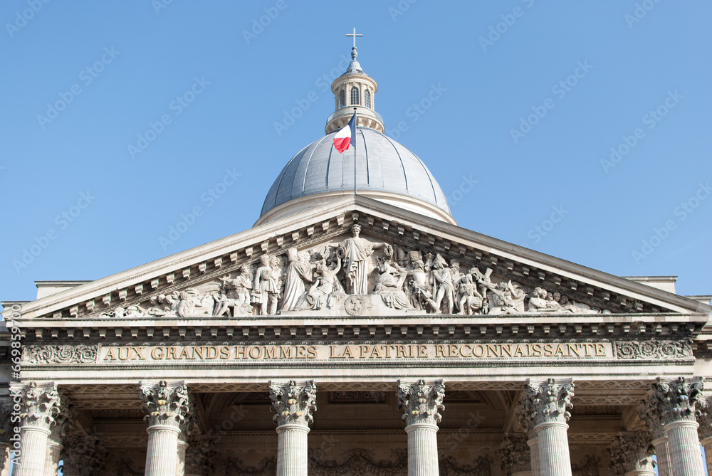 Cúpula del Panteón de París con la bandera francesa ondeando al viento y la fachada con esculturas en piedra en bajorelieve, francia