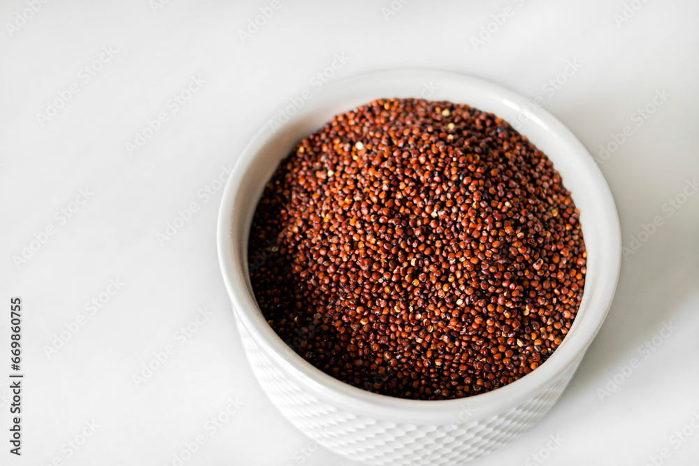 Red quinoa on the white plate on the white background. Healthy food and nutrition concept. Safe, ecological, and healthy products Red quinoa on the white plate on the white background. Healthy food and nutrition concept. Safe, ecological, and healthy products