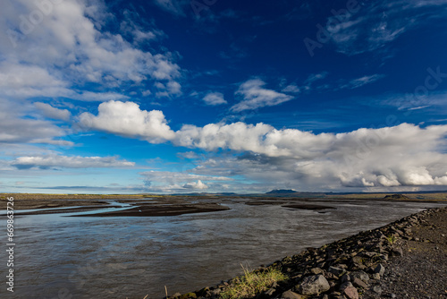 Scenery sky with clouds over the broad river  Southern Iceland  travel photograph taken from one bridge