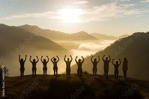 Healthy lifestyle  states of mind concept. Men and women doing yoga or meditation in mountains during sunny and warm summer sunset or sunrise. Dark human silhouettes in foggy mountains background