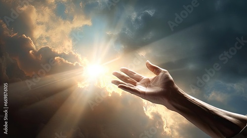 A man's hand reaches for the light in the clouds
