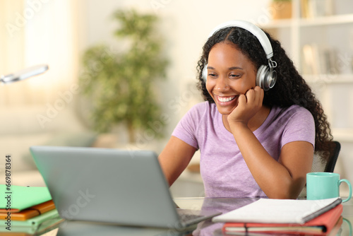 Happy black student eleaning online at home photo