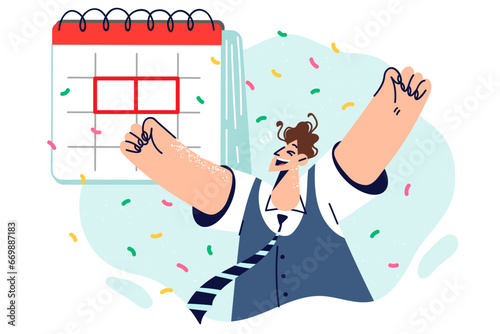 Satisfied man near calendar rejoices at approaching holiday and raises hands up as sign of success