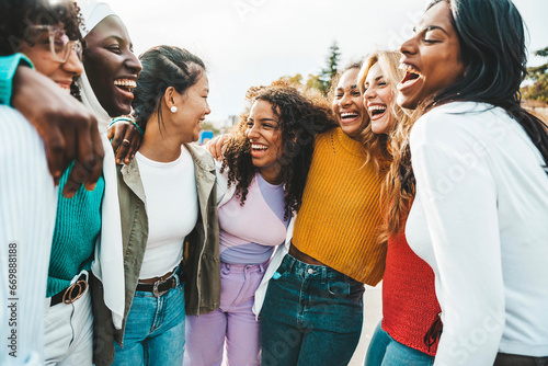 Multi ethnic group of young women hugging outside - Happy girlsfriends having fun laughing out loud on city street - Female community concept with cheerful girls standing together - Women  power photo
