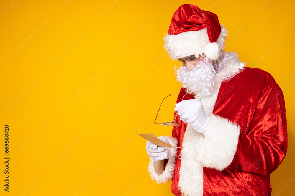 Santa Claus with a phone on a yellow background.