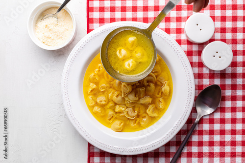 Obraz na plátně A ladle with homemade beef and chicken or capon broth with tortellini