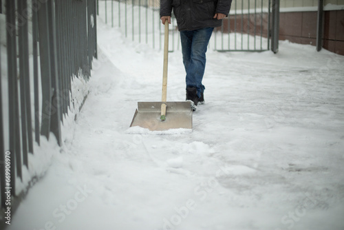 Snow removal on street. Shovel for track cleaning. Man cleans up yard.