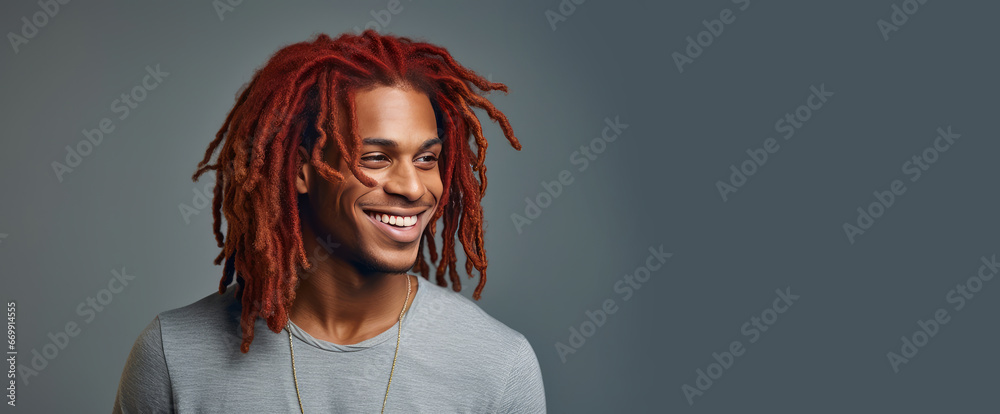 Portrait of an elegant sexy smiling African man with dark, perfect skin, red long hair, on a silver background.