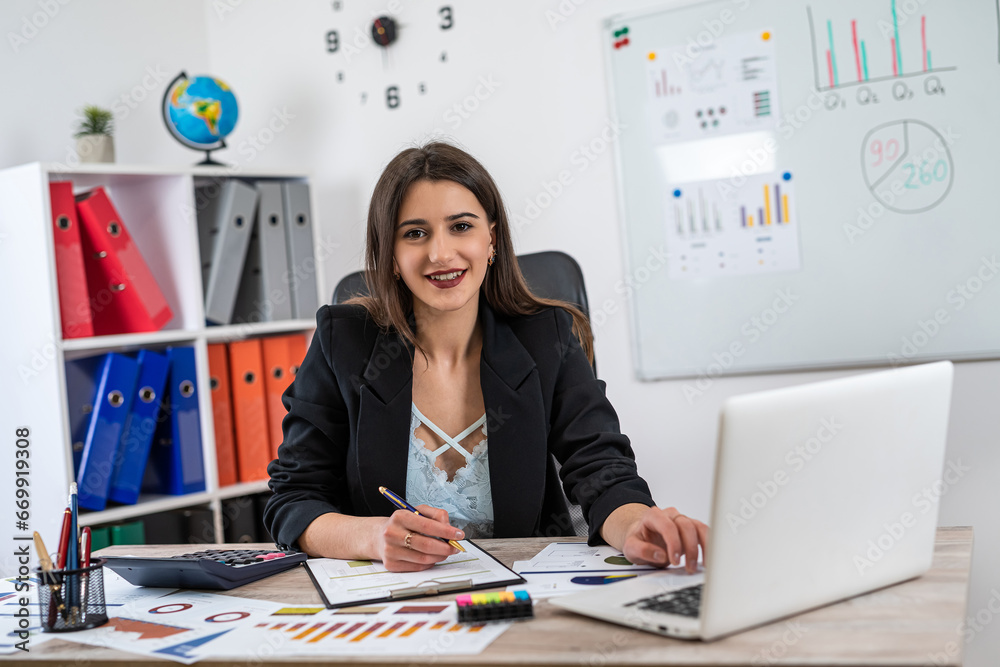 Single smiling business woman wear suit work with paper chart documents at office Single smiling business woman wear suit work with paper chart documents at office
