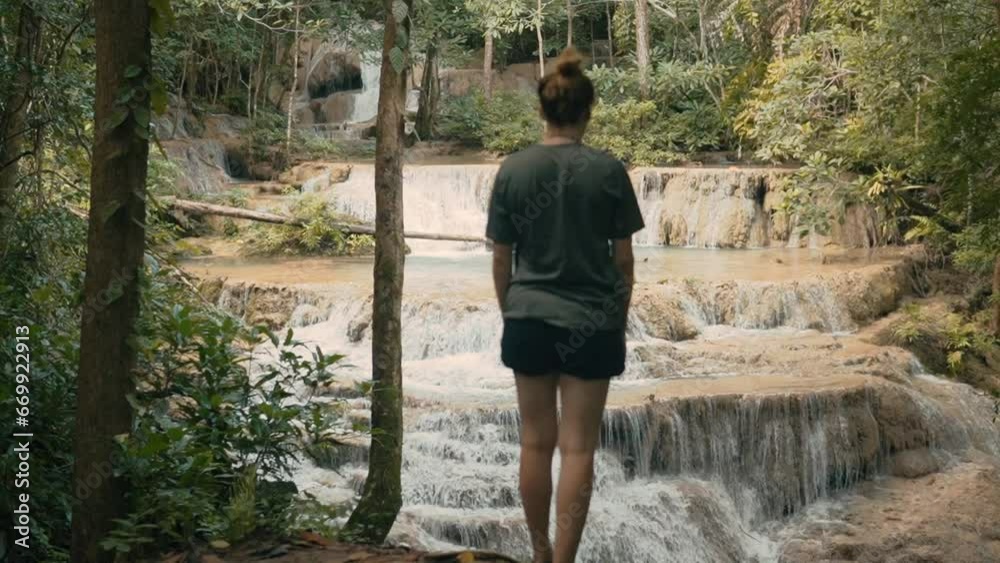 Attracitve Young Woman Hiking Next to Waterfall in Erawan National Park, Thailand Attracitve Young Woman Hiking Next to Waterfall in Erawan National Park, Thailand