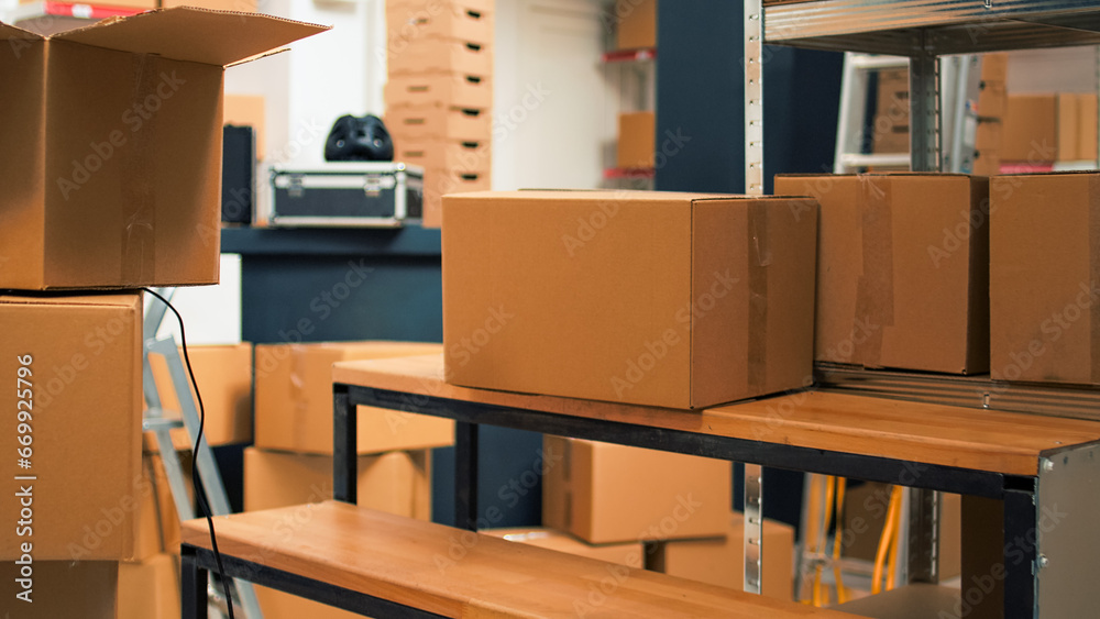 Startup storehouse filled with merchandise to ship to clients, products in cardboard packages used for business development. Empty storage room with carton boxes and stacks of supplies. Startup storehouse filled with merchandise to ship to clients, products in cardboard packages used for business development. Empty storage room with carton boxes and stacks of supplies.