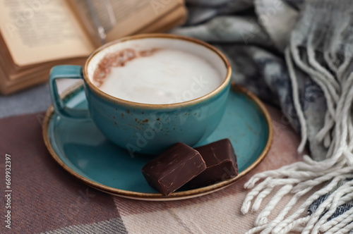 coffee mug , scarf and book on the table