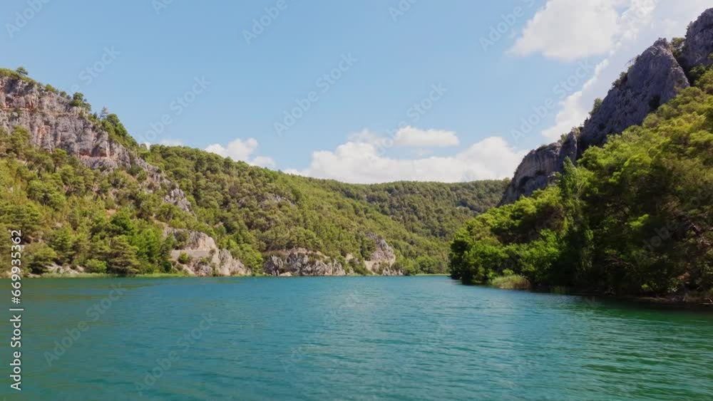 Aerial flight through the national park of Krka in Croatia with the turquoise water and steep mountain slopes with trees and bushes. Aerial flight through the national park of Krka in Croatia with the turquoise water and steep mountain slopes with trees and bushes.