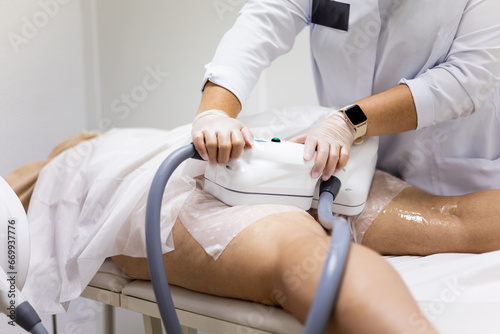 An unrecognizable woman visits a beauty center to undergo cryolipolysis therapy to remove fat from her legs. Cryolipolysis concept, eliminates localized fat in certain areas of the body. photo