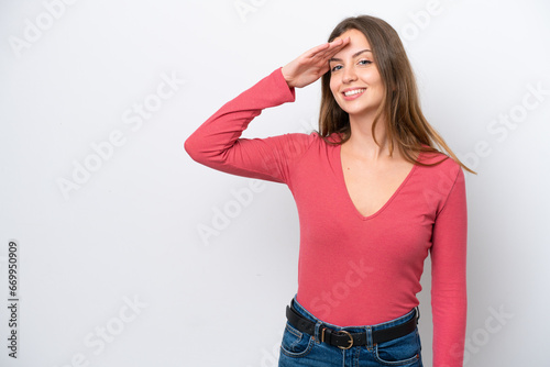 Young caucasian woman isolated on white background saluting with hand with happy expression © luismolinero