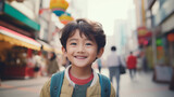  cheerful young asian kid looking at the camera standing on city street 